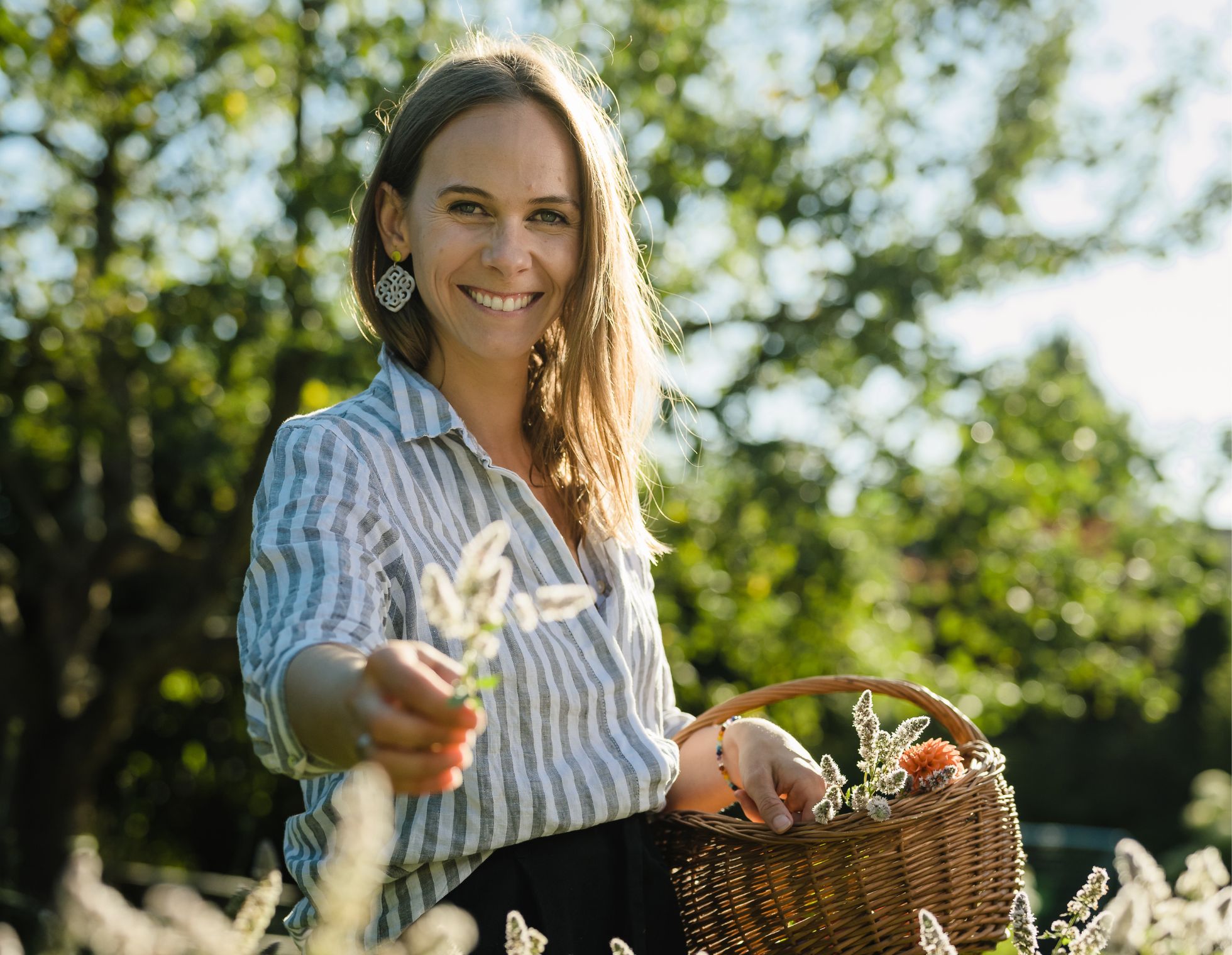 Erfahrene Diätologin Stefanie Bart beim Blumenpflücken – ein Sinnbild für ihre Hingabe an ausgewogene Ernährung und Förderung gesunder Lebensweisen. Sie bietet maßgeschneiderte Ernährungspläne und persönliche Beratung an.